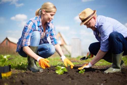 Gardening worker managing tools and weather-related safety on site